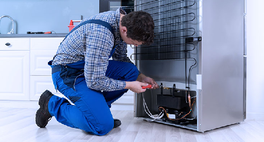 Technician repairing refrigerator
